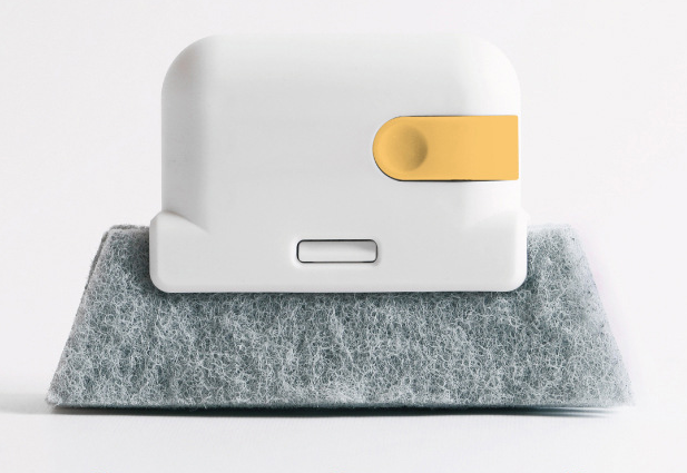 Front view of a white cleaning brush with yellow accent and grey pad on a plain background