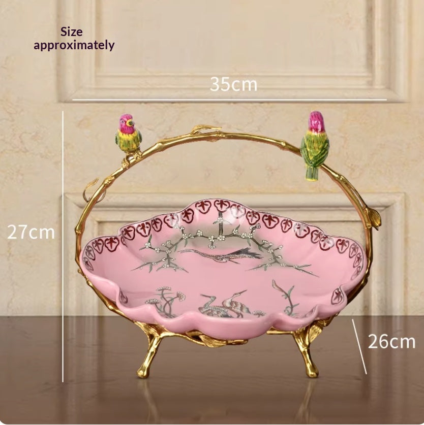 Pink ceramic fruit bowl with crane and branch motif, gilt branch handle with two birds, size chart showing dimensions