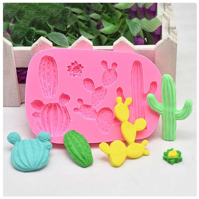 Pink cactus and succulent silicone mould with various coloured cactus shapes in front, displayed on white surface with green