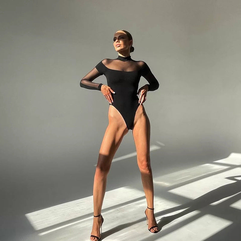 Model in black mesh mock-neck bodysuit and heeled sandals, standing in sunlight, front view