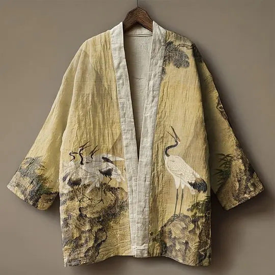 Open-front kimono jacket with wide sleeves, beige with crane and rocky landscape print, front view on hanger