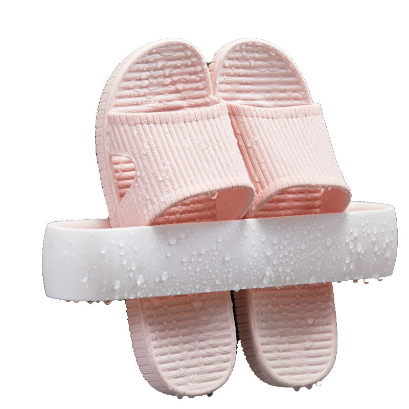 White wall-mount slipper rack with pink slippers, water droplets visible, front view, isolated on white background