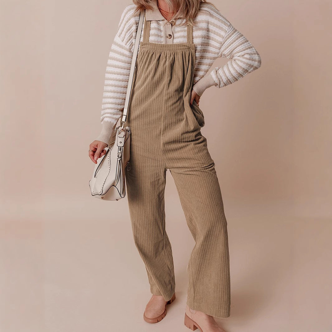 Front view of beige corduroy wide-leg dungarees with vertical stripes, worn with striped top and white shoulder bag