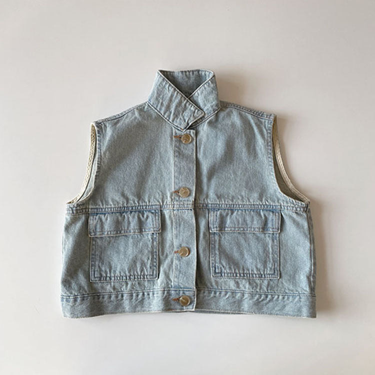 Light blue denim vest laid flat, cream binding at the armholes
