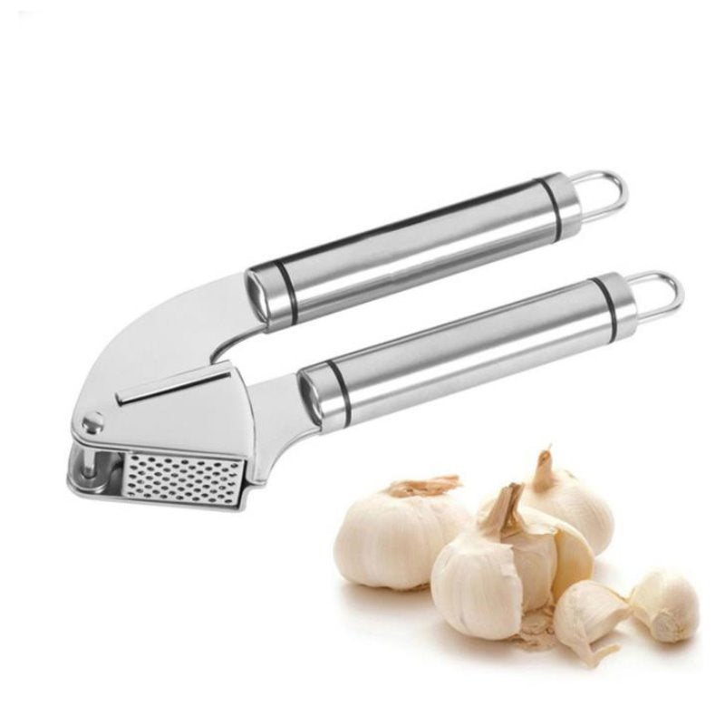 Stainless steel garlic press with two handles, perforated plate, and hanging loops, shown with garlic bulbs on white