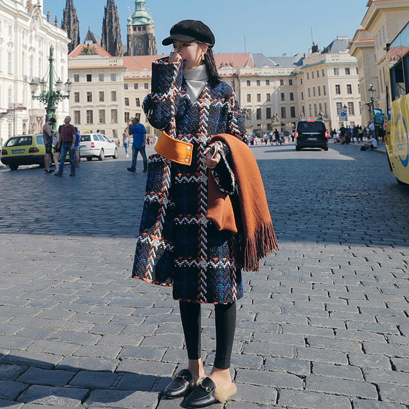 Full-length front view of the check cocoon coat, model holding a phone and an orange scarf