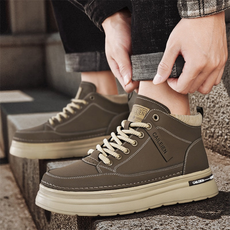 Men's high-top lace-up sneaker boots in grey, worn on feet, hands adjusting jeans cuff, stone steps background