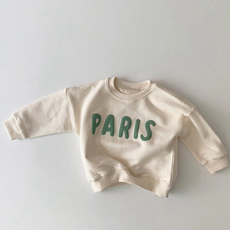 Witte trui met groene PARIS-letters plat neergelegd