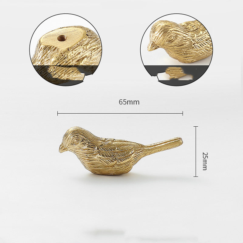 Gold-tone bird-shaped cabinet knob, front view with detail of back and head, flat lay on white background