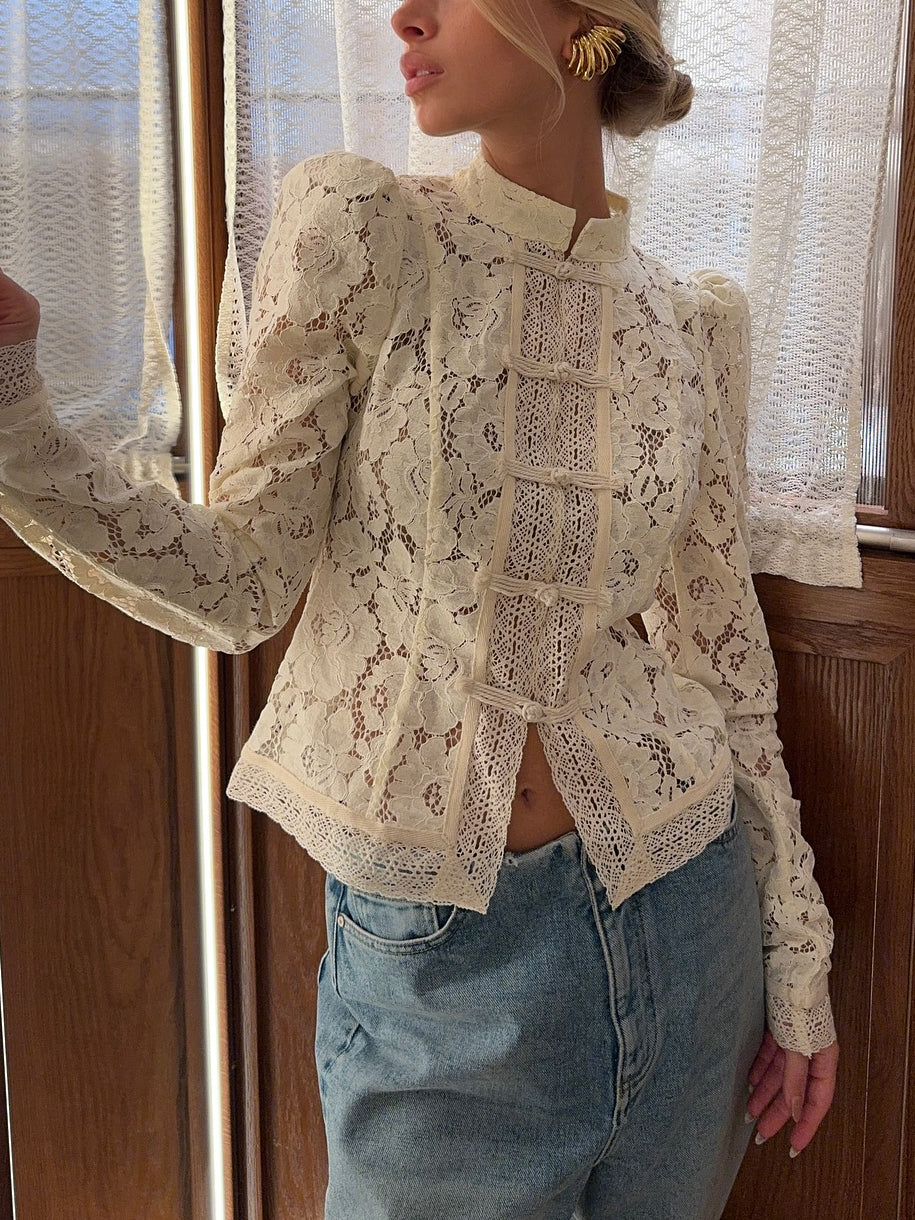 Lace-panel long sleeve blouse with puffed shoulders, cream floral lace, stand collar, front closure, worn by model with jeans