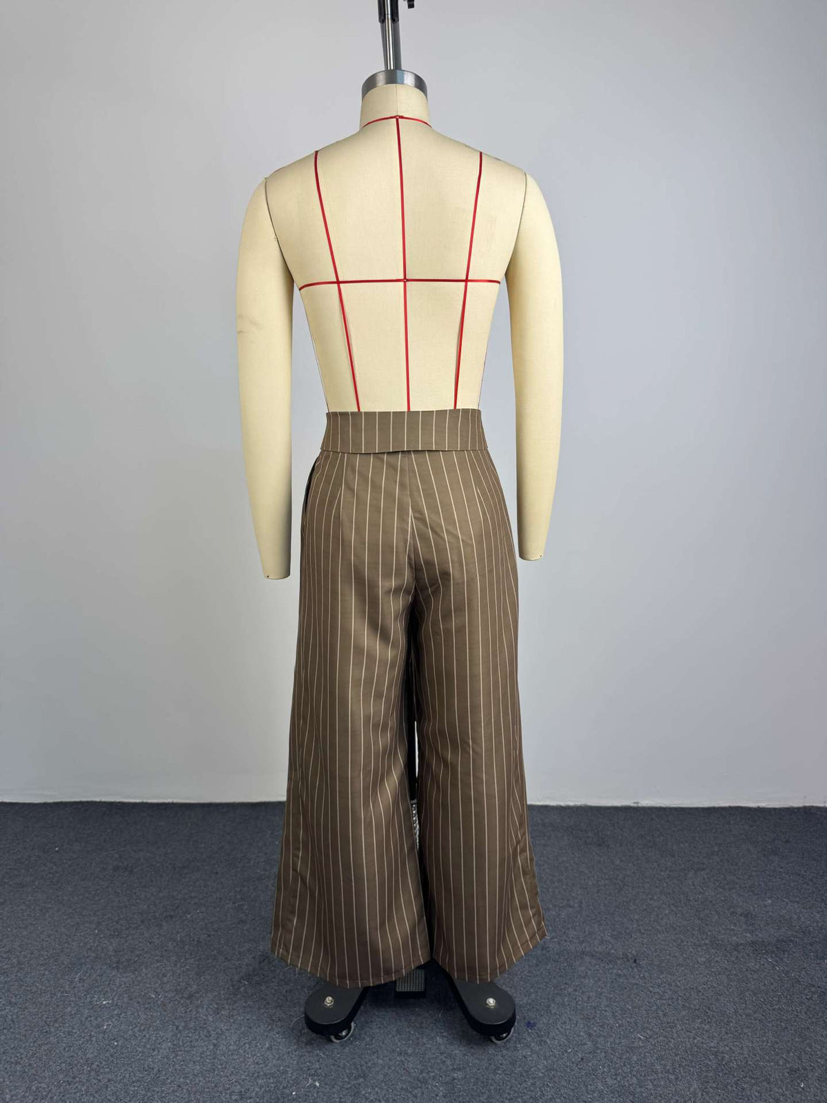 Back view of brown pinstripe wide-leg trousers on dress form, showing full wide-leg silhouette