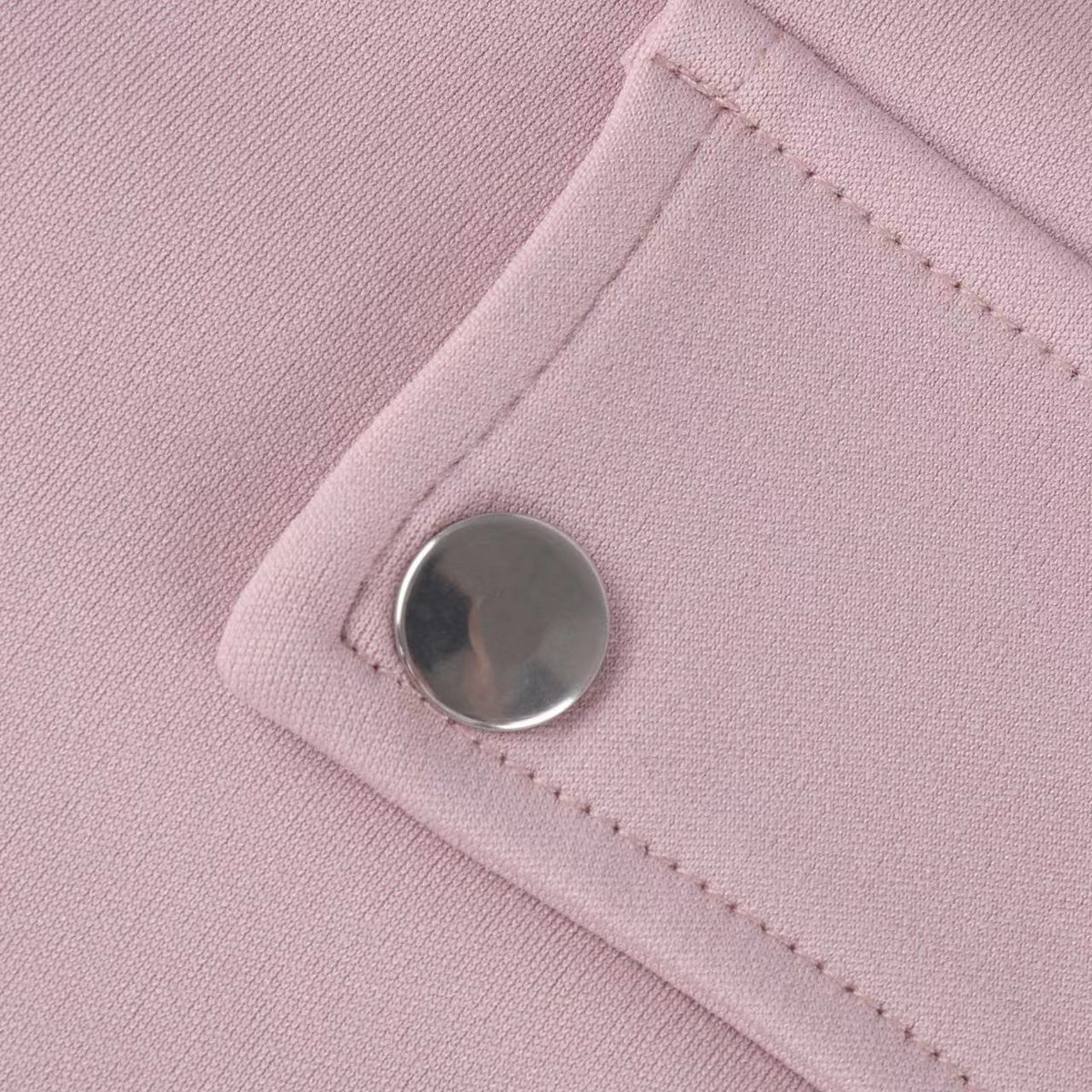 Close-up of button detail on dusty pink sweatshirt
