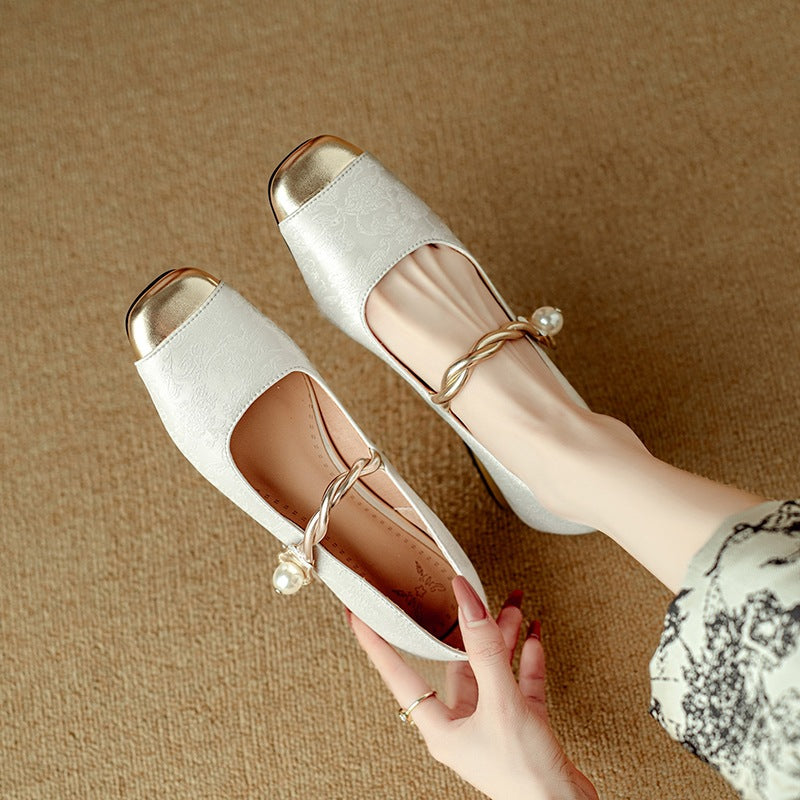 Retro Mary Jane pumps in silver with gold-tone toe cap and pearl-look strap, worn on feet, top view