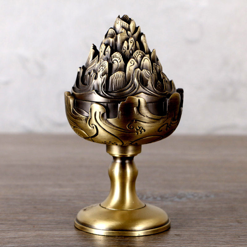Mountain-shaped brass-look incense burner with lid, antique bronze-tone, front view on wooden surface