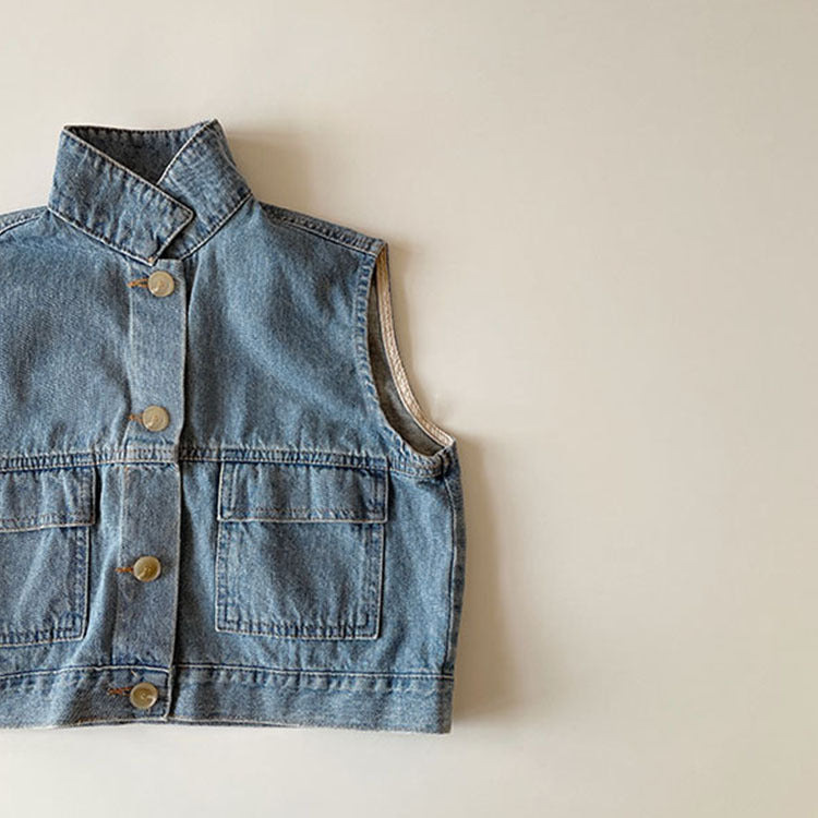 Deep blue denim vest laid flat, buttons and chest pockets