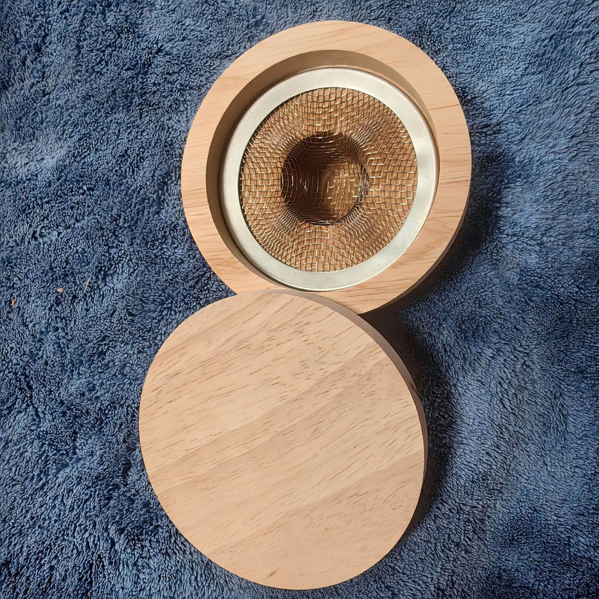 Round beech wood cocktail smoker top seen from above, with fine metal mesh basket and separate flat wooden lid