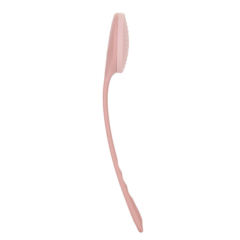 Side view of the curved long-handle back lotion applicator in light pink