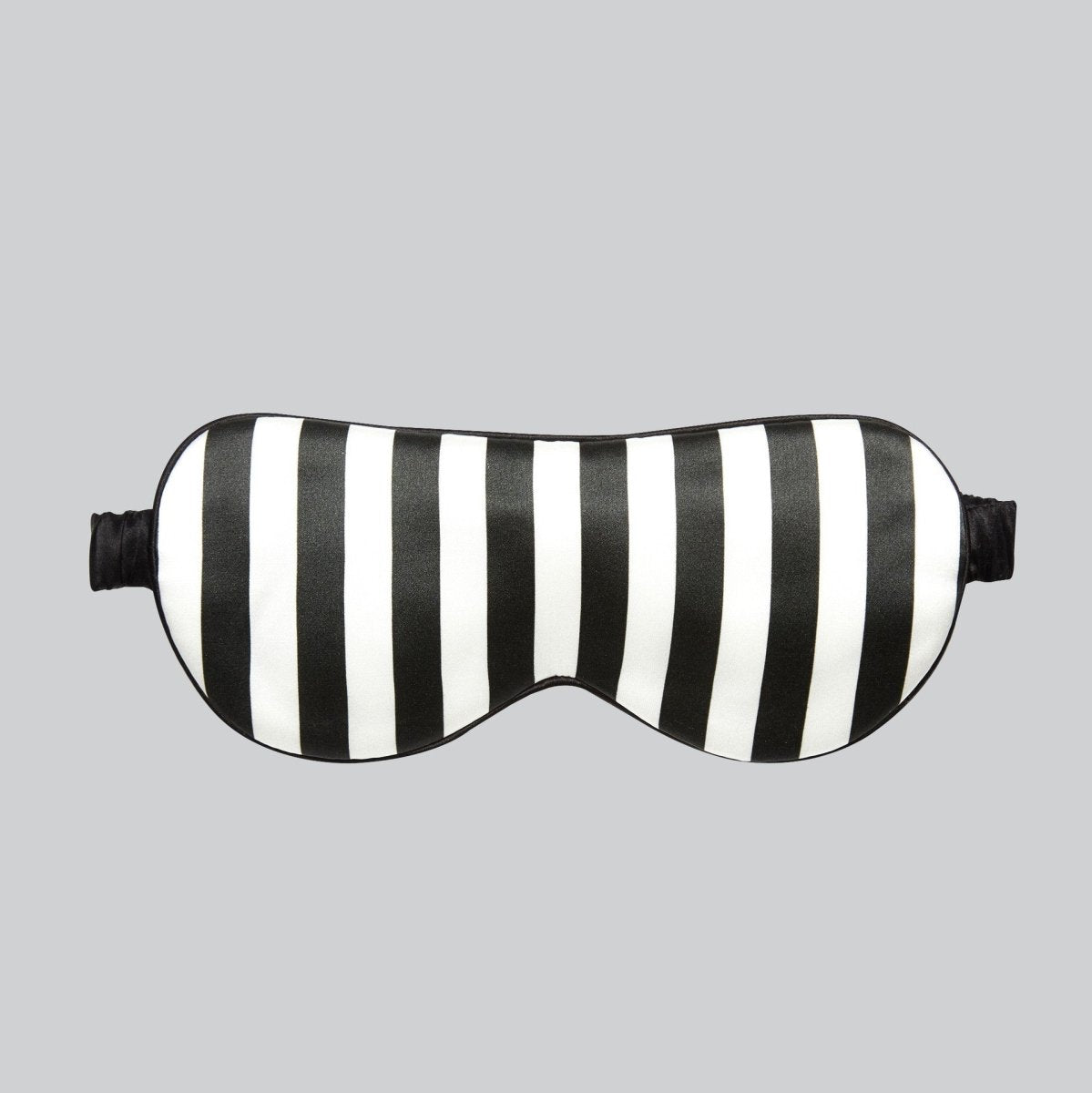 Black and white striped mulberry silk sleep mask, front view on a grey background