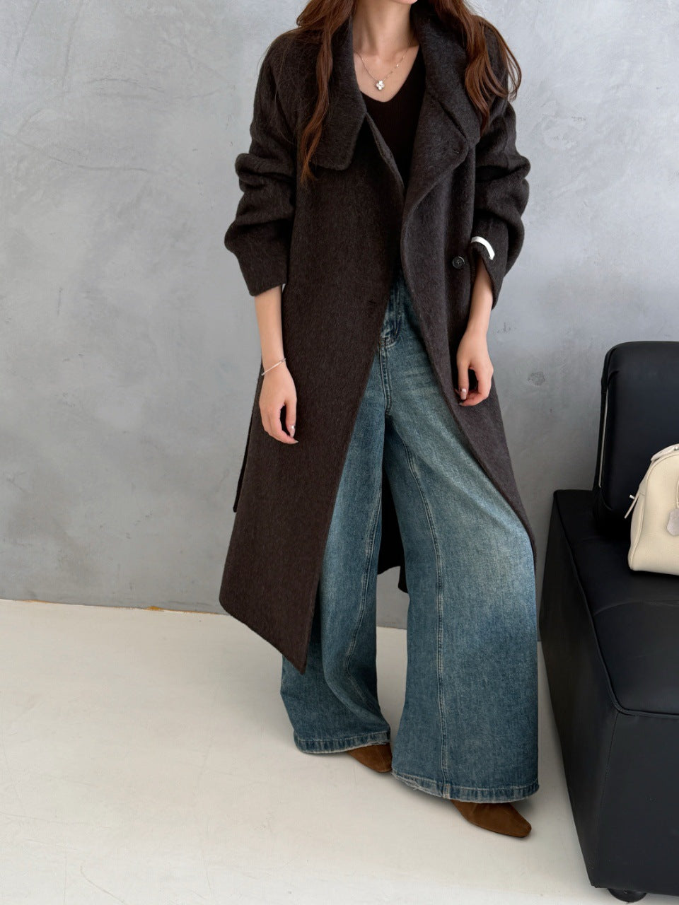 Dark brown wool coat with stand collar, worn open over wide-leg jeans