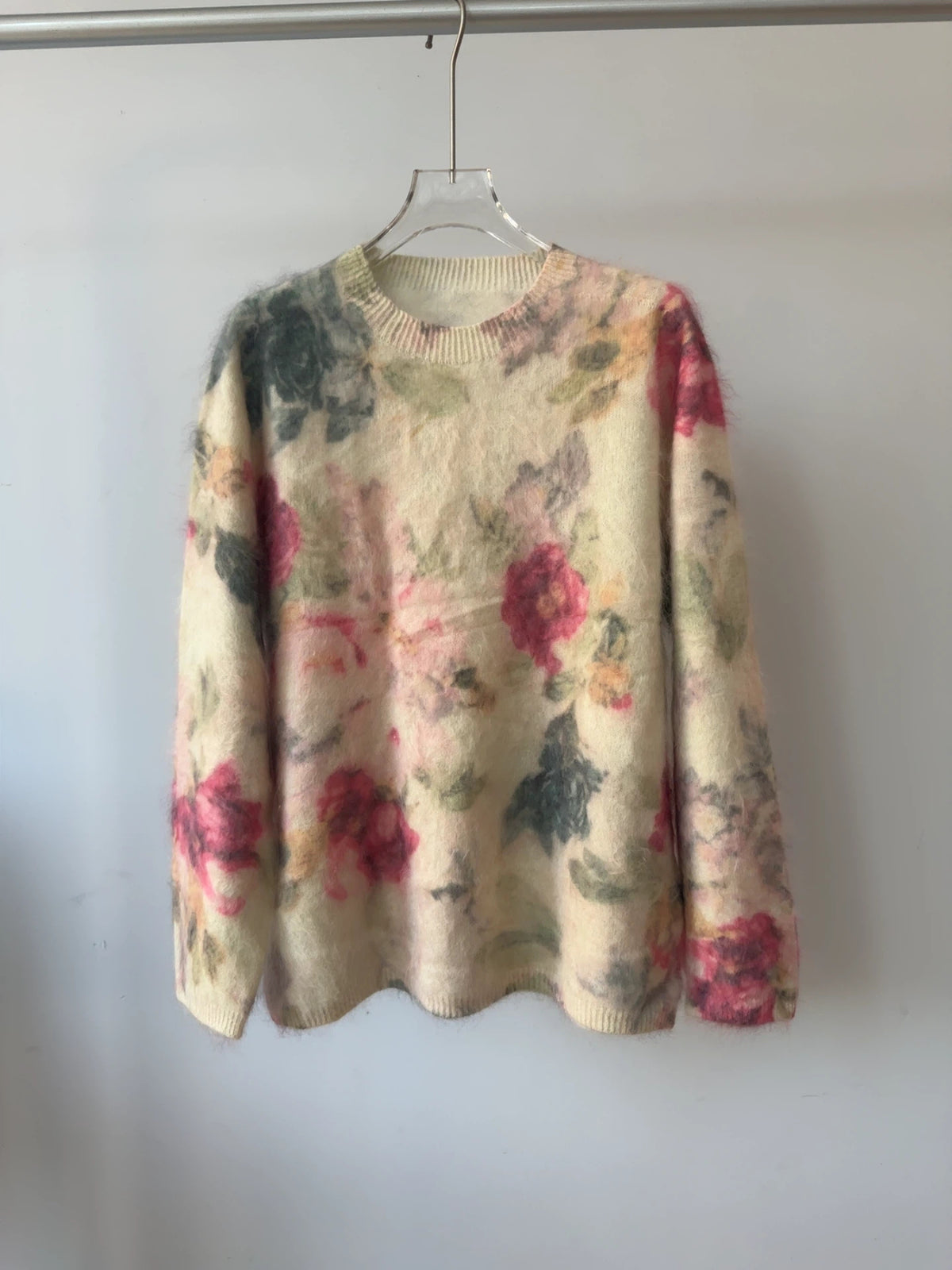 Geborstelde wollen trui met de print inkt bergbloemen, rode rozen en grijsgroene bladeren op een crèmekleurige basis, aan een hanger