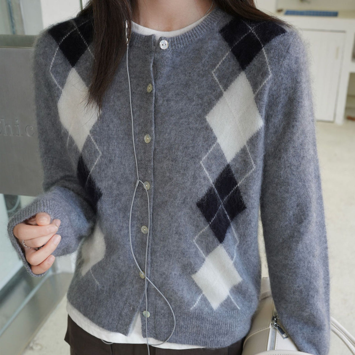 Middengrijs vest met donkergrijze en gebroken witte argyle ruiten, close-up vooraanzicht