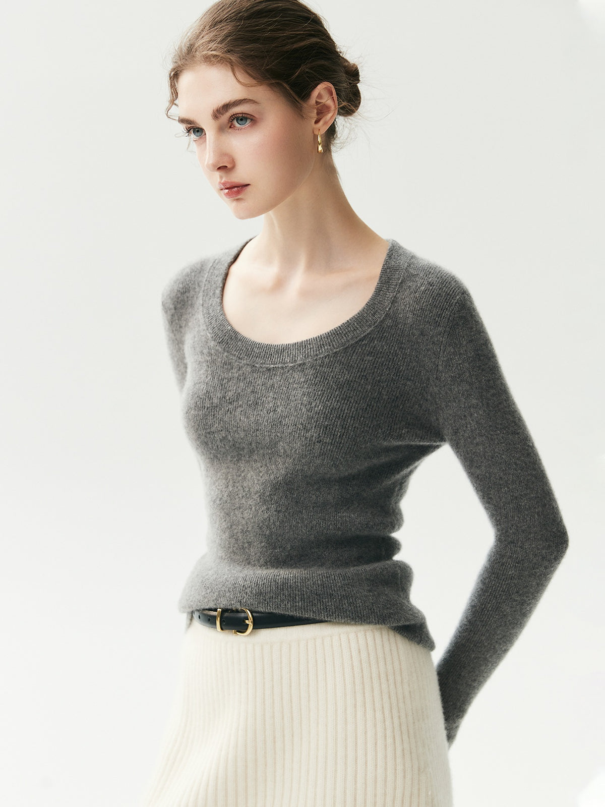 Antraciet geribde cashmere trui met U-hals op een model, zicht op driekwart met cream rok