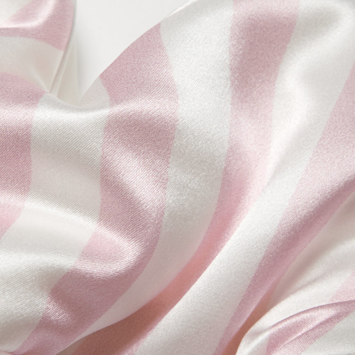 Close-up of pink and white striped mulberry silk fabric with a smooth, glossy surface