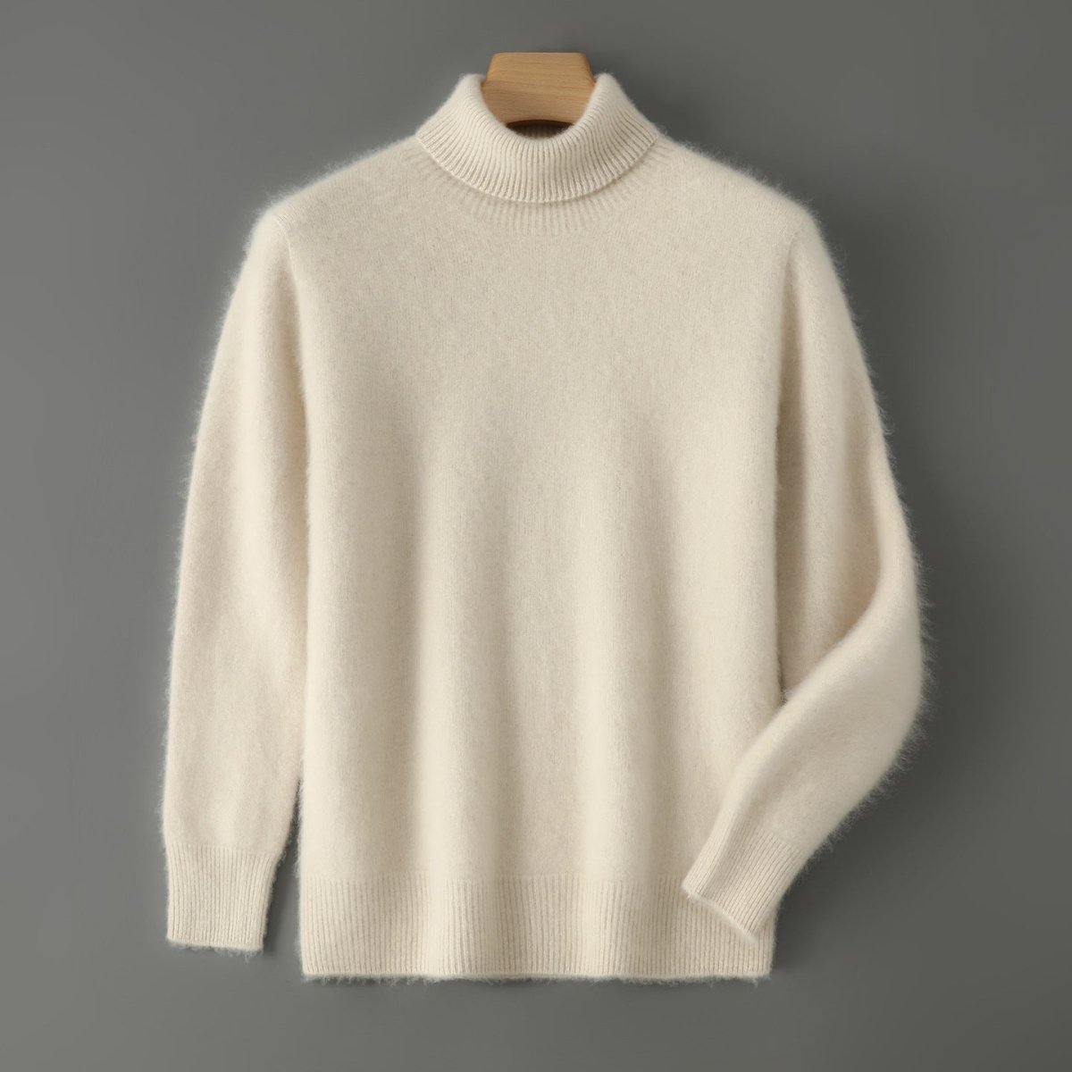 Crème wollen coltrui heren aan een hanger tegen een grijze muur