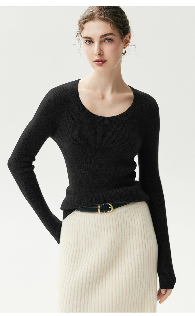 Zwarte geribde cashmere trui met U-hals op een model, vooraanzicht op driekwart met cream geribde rok