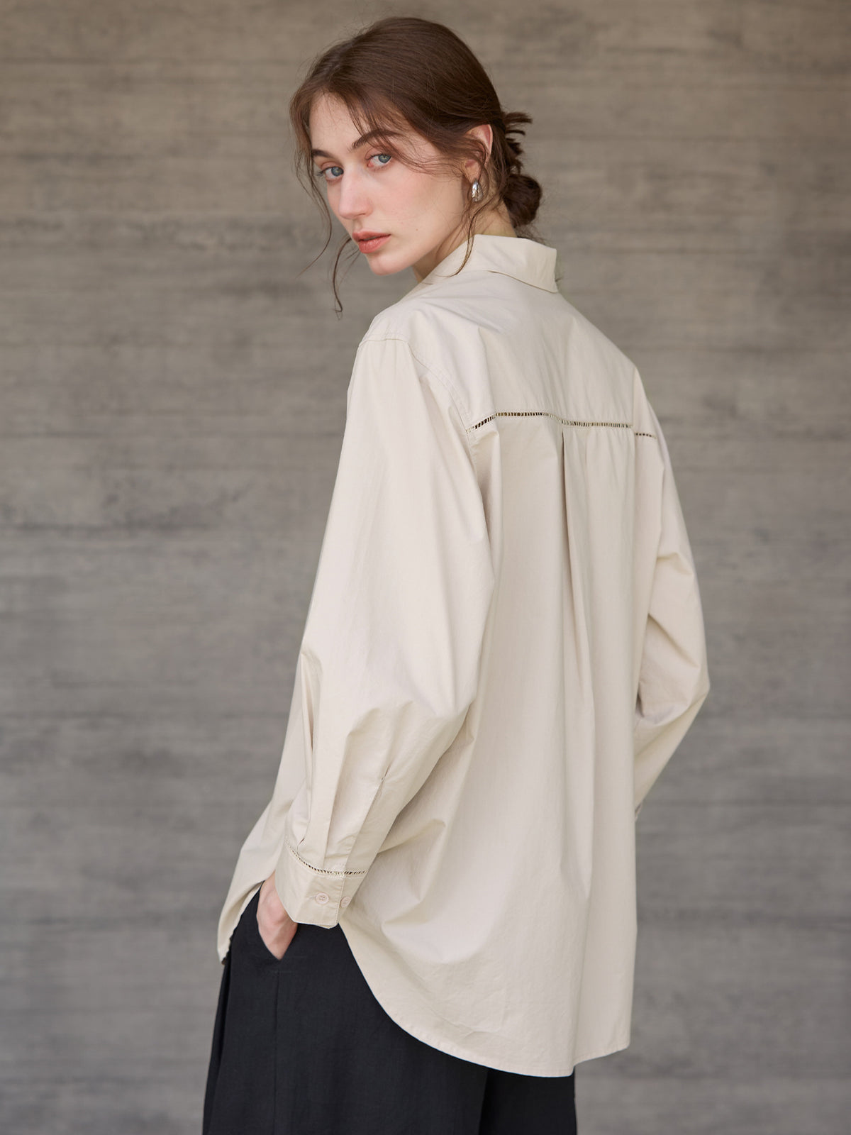 Relaxed long-sleeve shirt with dropped shoulder in beige, worn by a model, back view, hands in pockets
