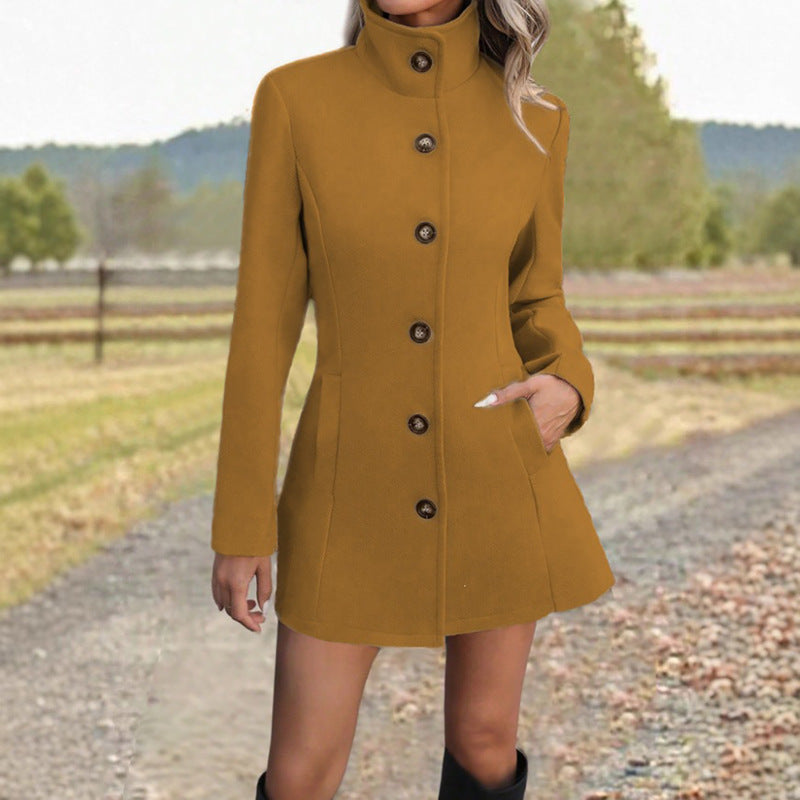 Fitted stand-collar coat in khaki, single-breasted with button front, worn by model on gravel path
