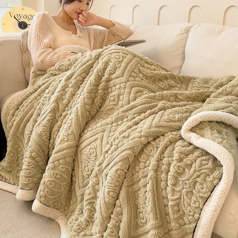 Embossed diamond-pattern velvet-look blanket in beige, spread over a sofa with a person sitting, showing size and texture