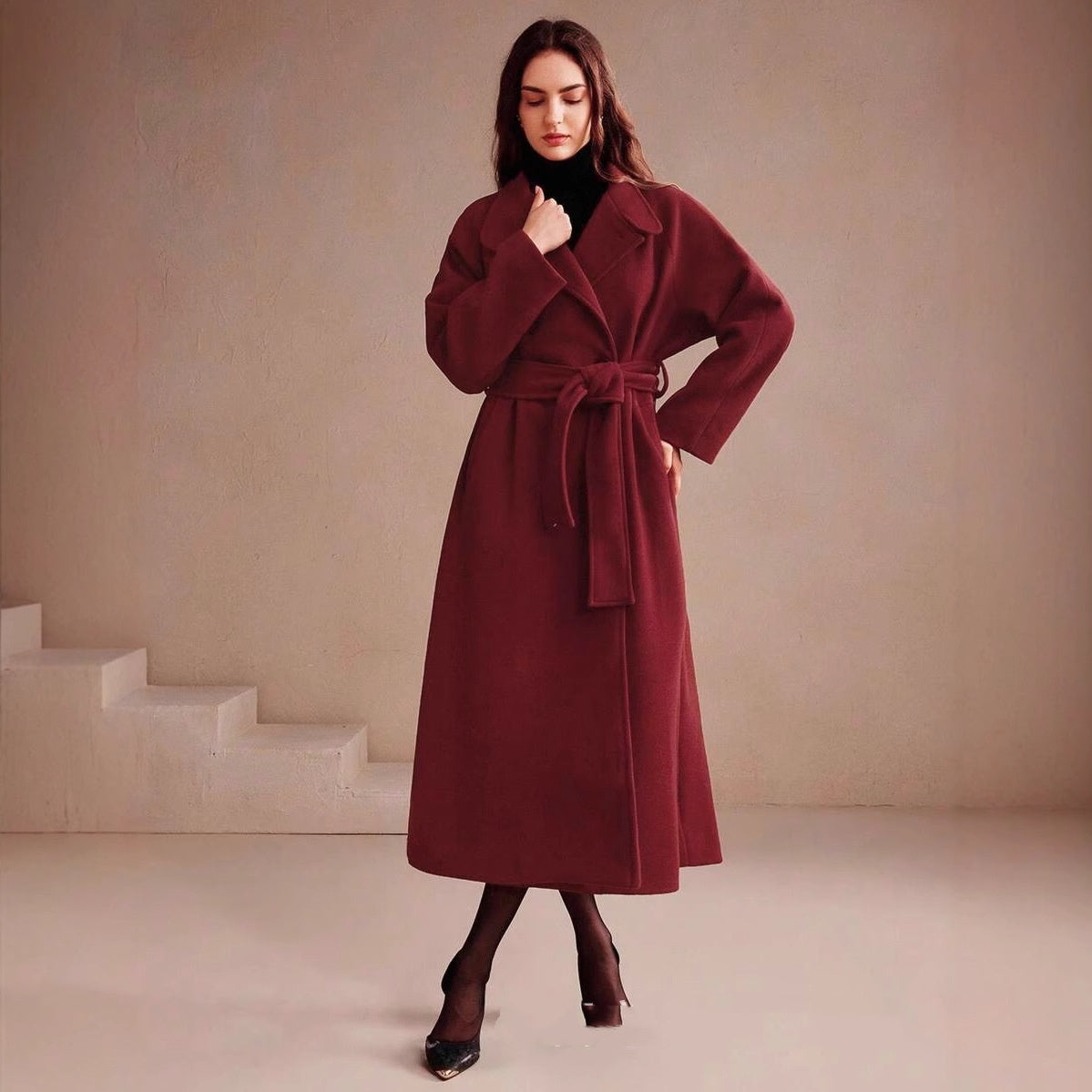 Long double-breasted wrap coat in wine red, tied belt, model standing, front view