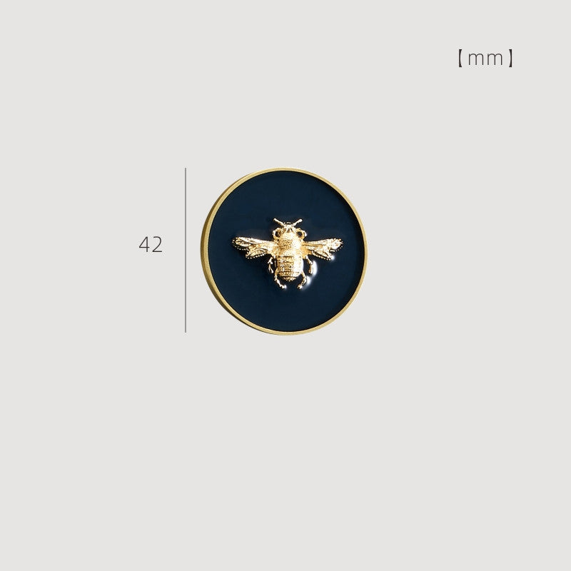 42 mm enamelled drawer knob with gold-tone rim and blue background featuring a bee design