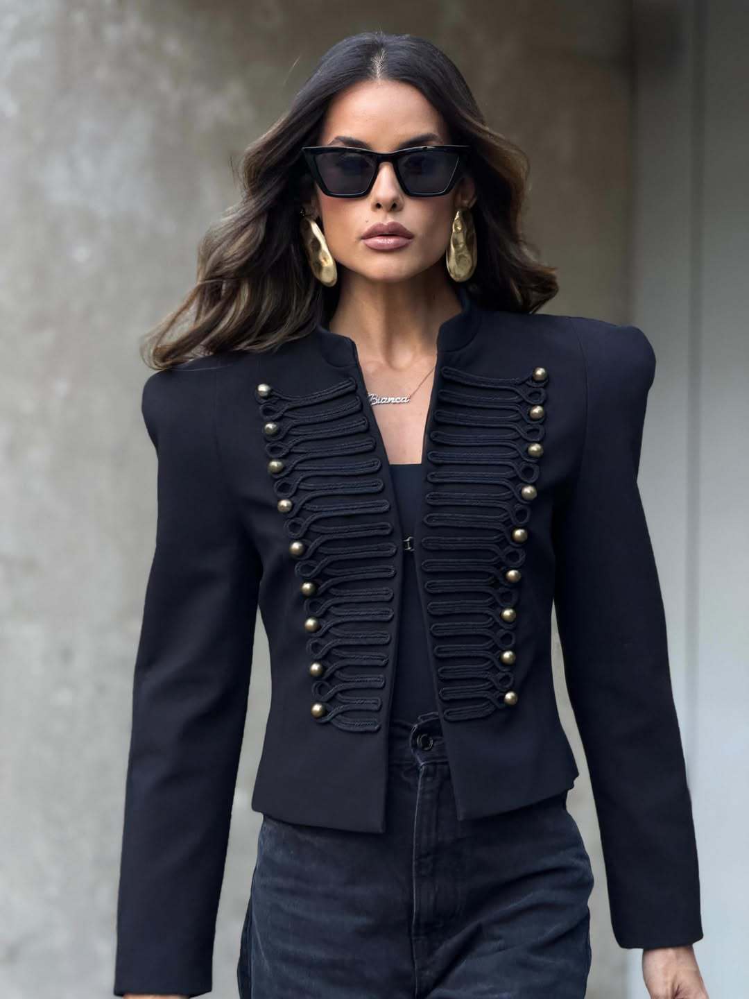 Black cropped structured blazer with gold-tone stud buttons and braid trim, front view on a model