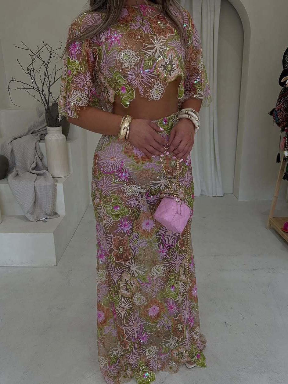 Pink, green and brown floral mesh crop top and maxi skirt set, three-quarter view with small pink bag