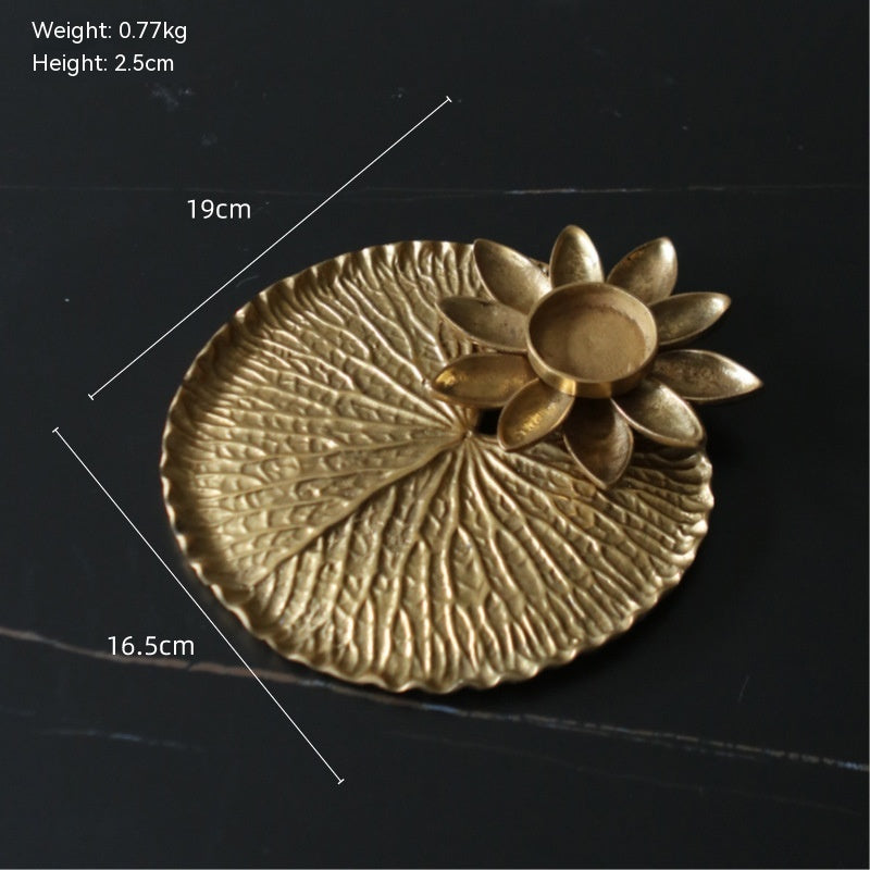 Brass lily pad tray with lotus tealight holder, front view, gold colour, textured surface, dimensions shown, on dark