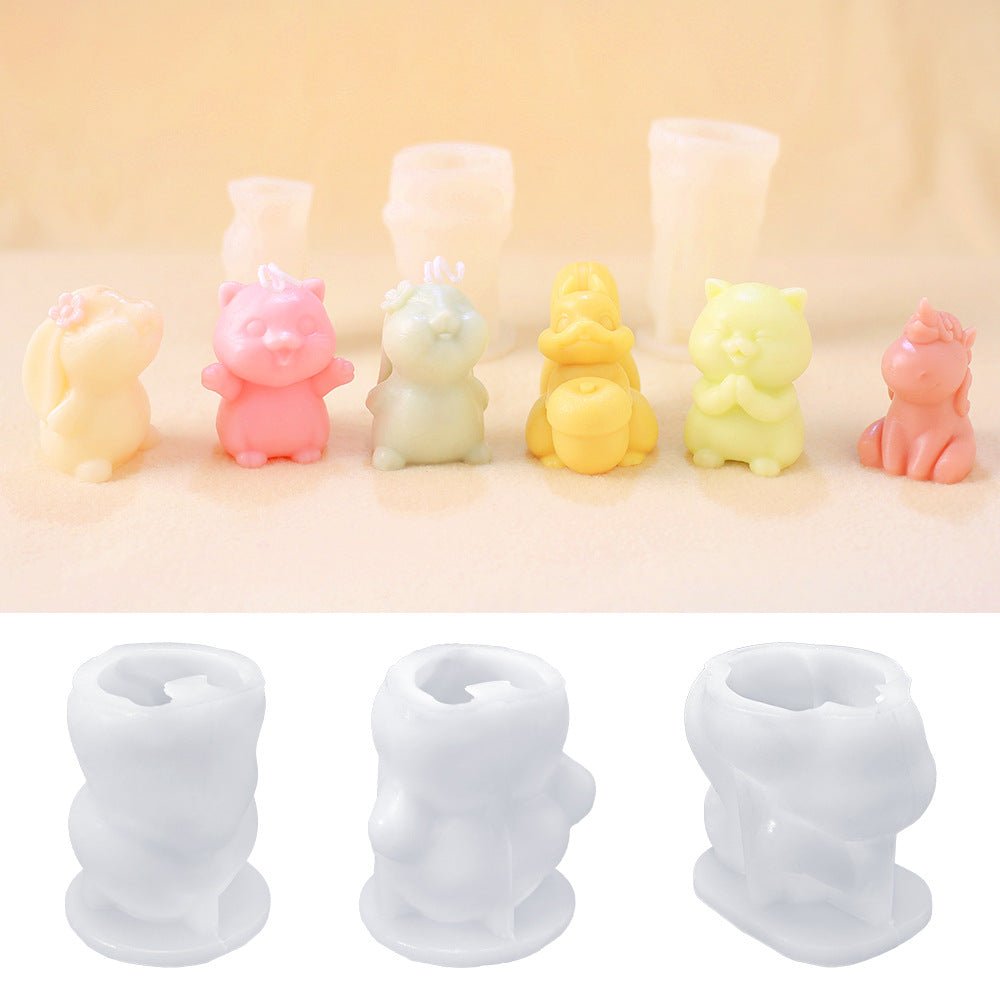 Row of small animal wax figures in pastel colours with three translucent silicone moulds for candles below