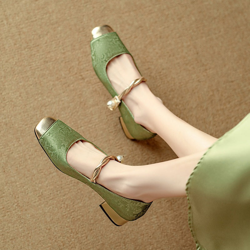 Retro Mary Jane pumps in green with gold-tone toe cap and pearl-look strap, worn on feet, side view