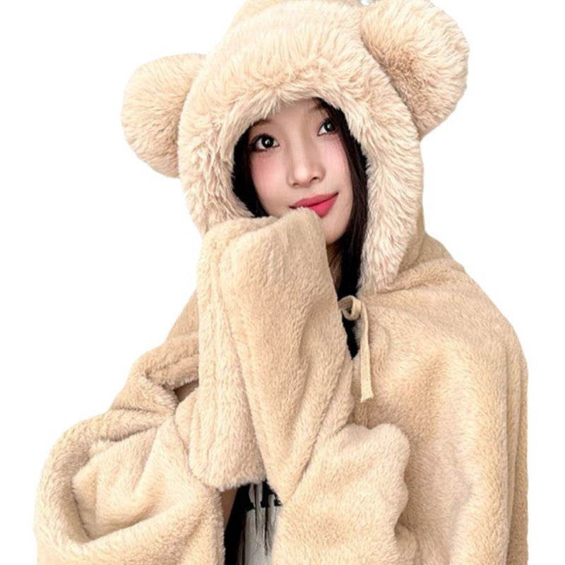 Beige hooded fleece nap cape with bear-ear hood and drawstring, worn by a model, front view, indoor setting