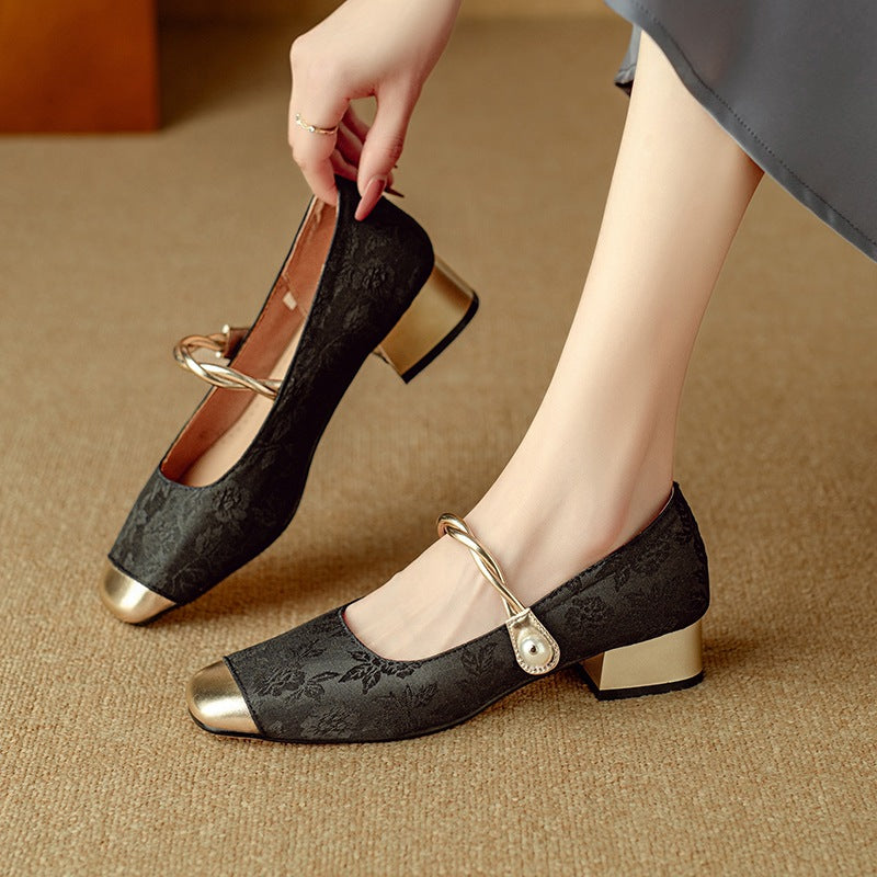 Retro Mary Jane pumps in black with gold-tone toe cap and pearl-look strap, one on foot, one held, front view
