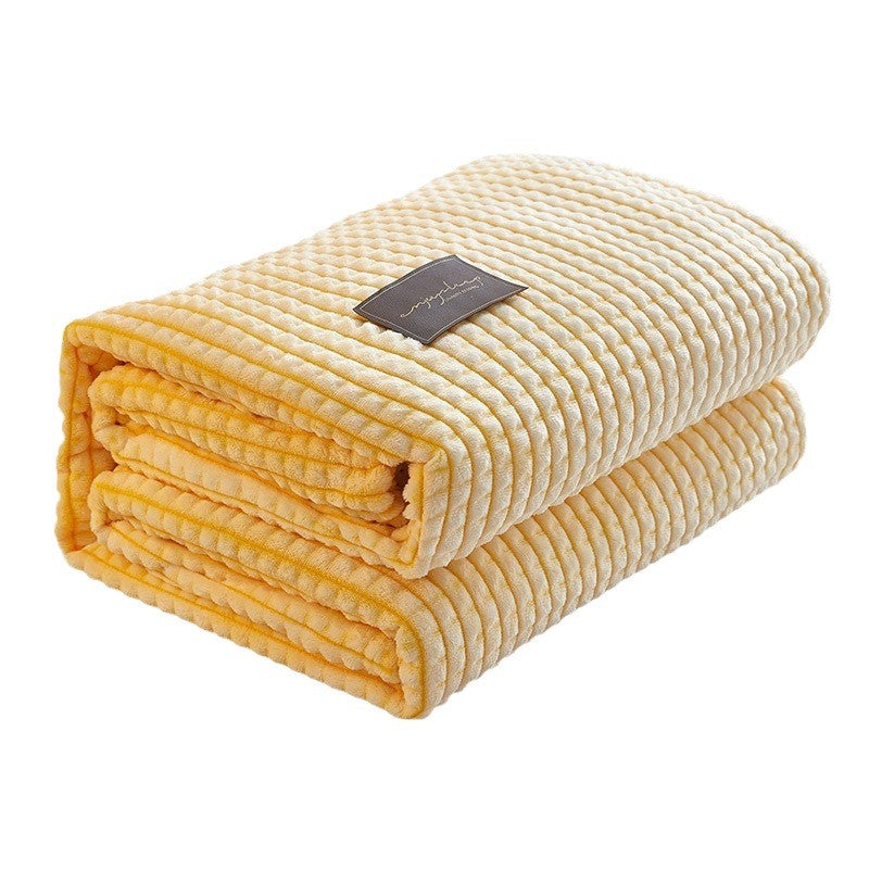 Folded waffle-knit coral fleece throw blanket in lemon yellow, shown against a white background