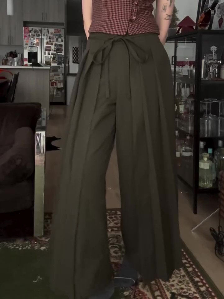 Olive wide-leg trousers with tie waist, front view on model in living room setting