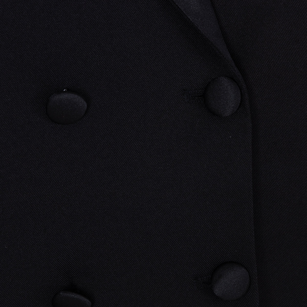 Close-up of the covered buttons on the matte black fabric