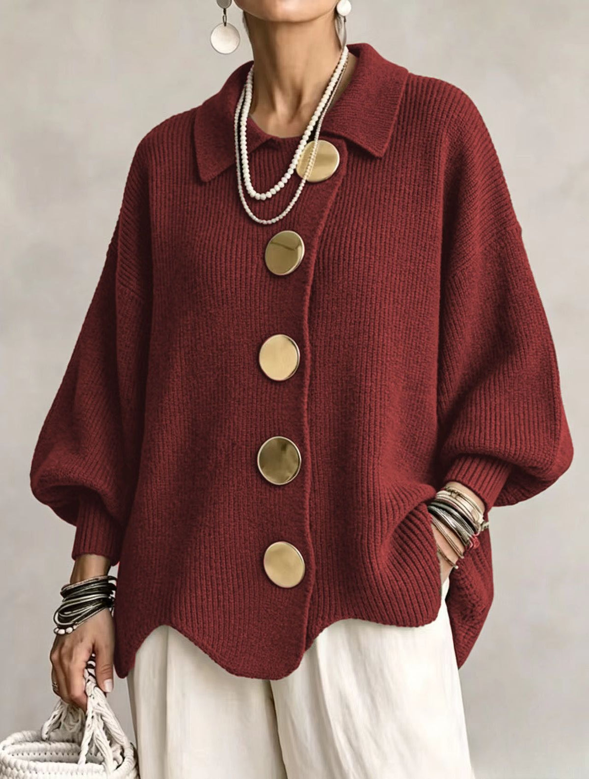 Collared knit cardigan in burgundy with large gold buttons, worn on a model, front view, wavy hem, dropped shoulders