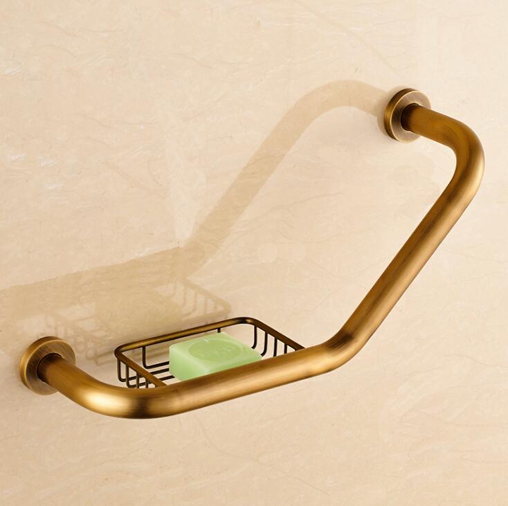 Antique gold wall grab bar with wire soap basket, angled design mounted on beige wall