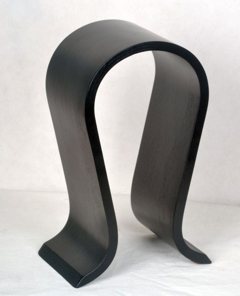 Black bent wood headphone stand standing empty on a white cloth