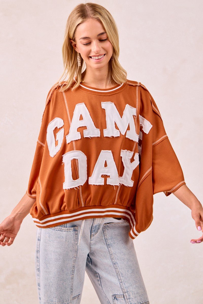 Person wearing white 'GAMEDAY' long-sleeved top with patchwork stitch detail on soft French terry fabric – GameDay Casual Swe