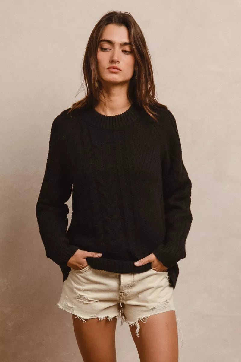 Model wearing BiBi Twist Knitted Open Shoulder Sweater in soft grey, showcasing relaxed fit and open shoulder detail