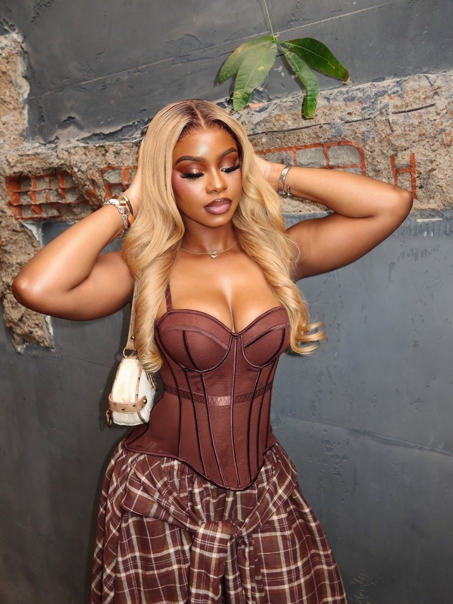 Boned corset top and asymmetric plaid skirt co-ord set in brown and beige, worn by model from front, hands on hair, against